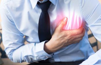 мужчина держится за больное сердце