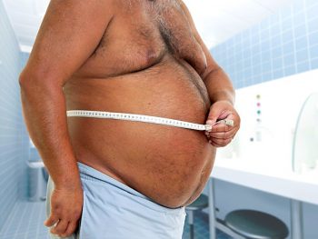 мужчина измеряет живот